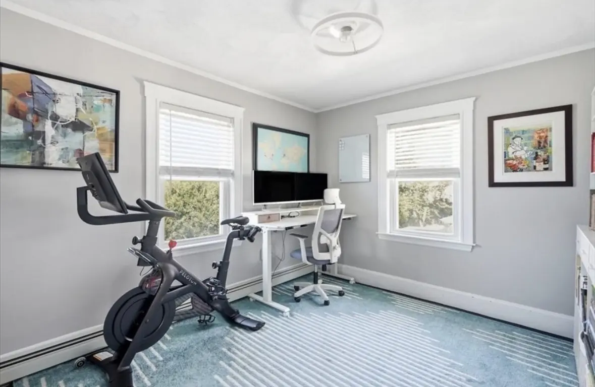 Flexible room used as a home office and gym with standing desk and exercise bike