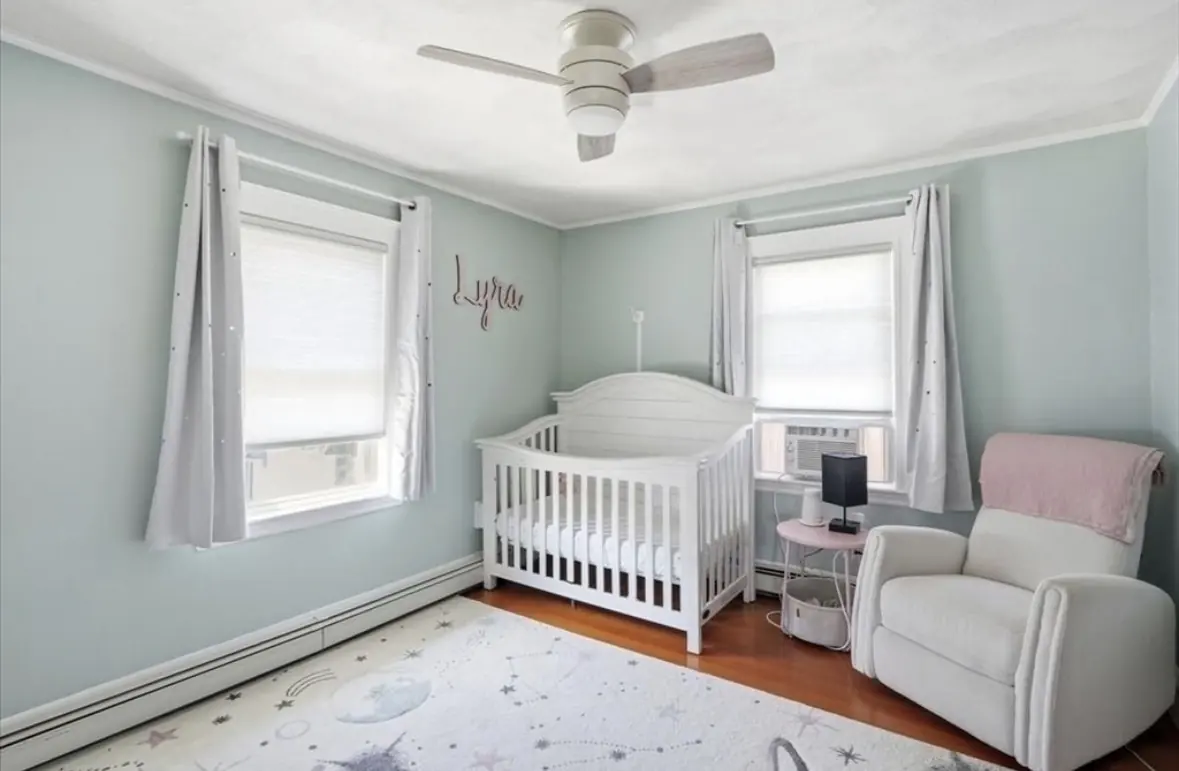 Nursery with sea glass green walls, crib and glider chair