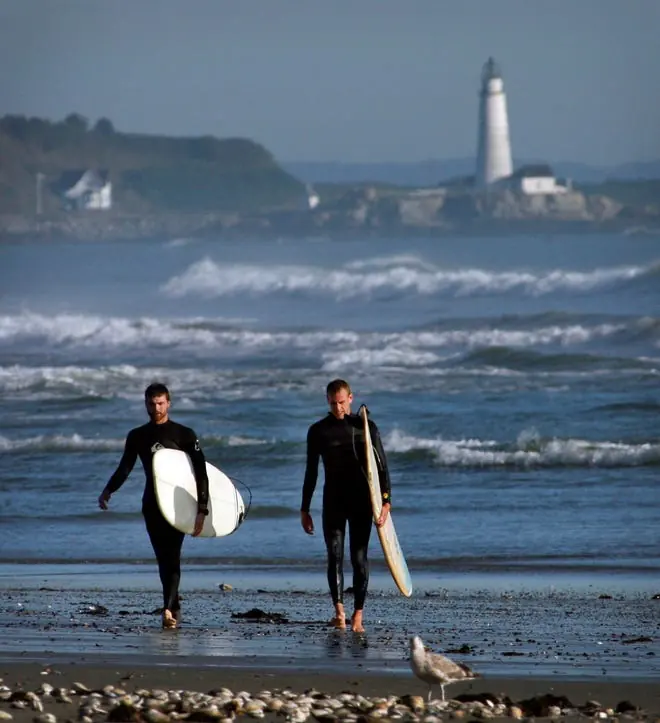 Surfers in the water off Hull with Boston Light in the distance