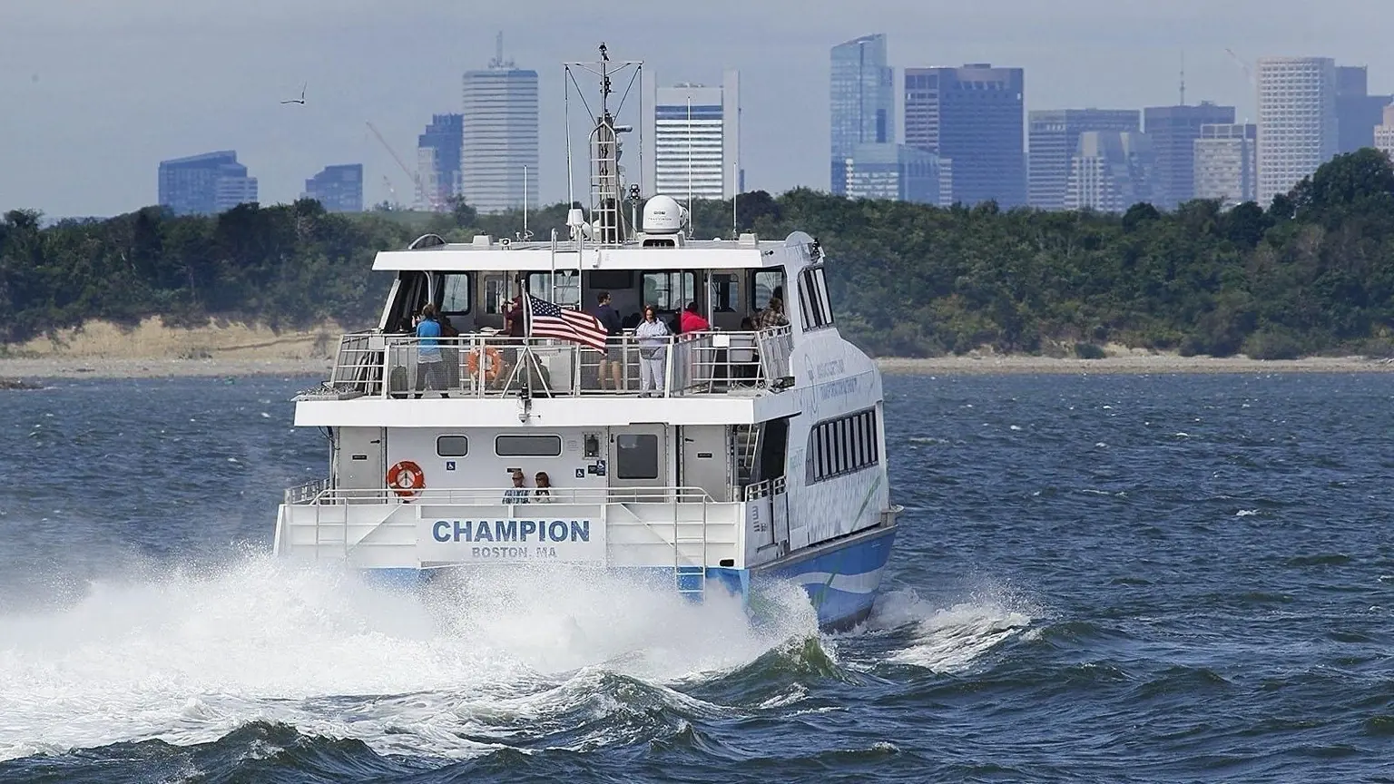 Commuter ferry crossing the harbor with the Boston skyline behind it
